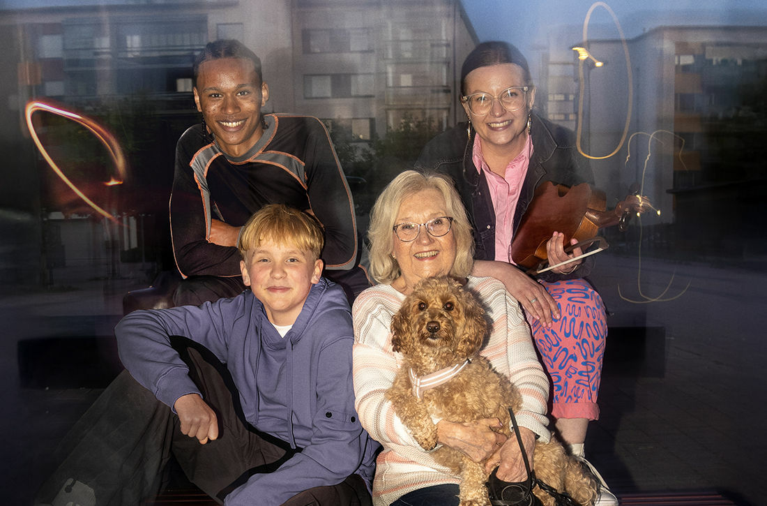 Eri-ikäisiä, hymyileviä kaupunkilaisia yhdessä